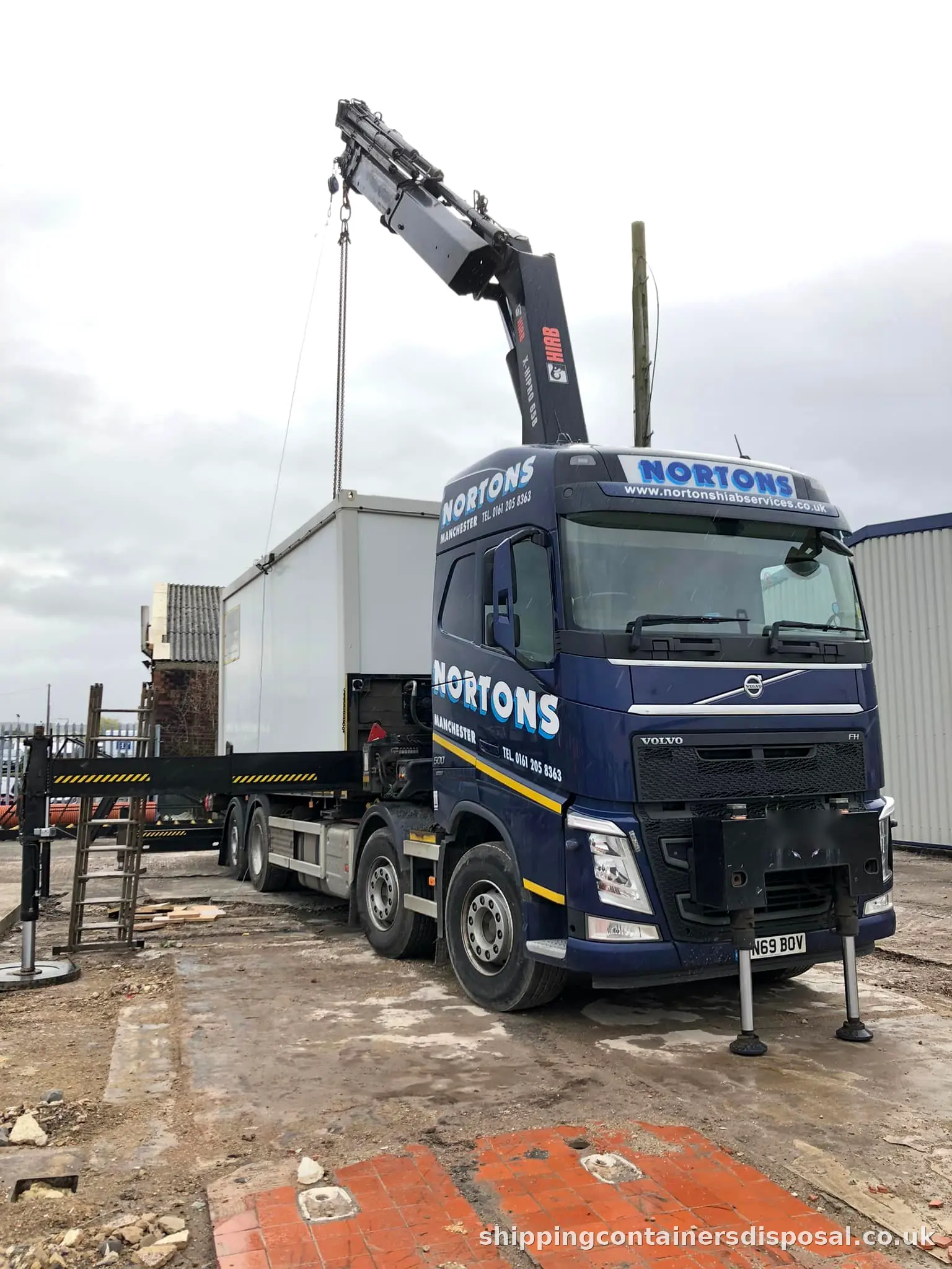 HIAB lorry with stabiliser legs down lifting a cabin