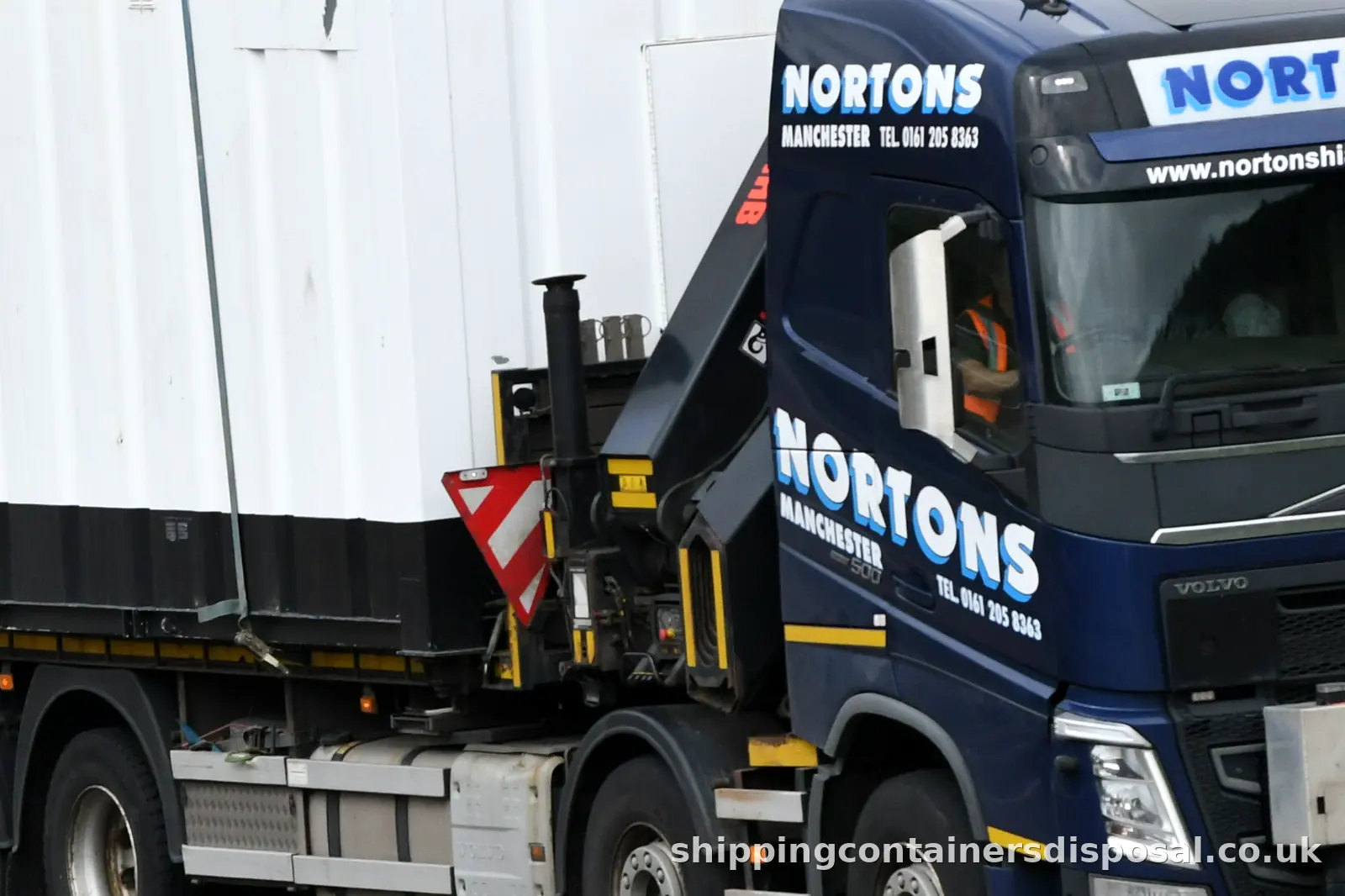 Wider view of a HIAB lorry carrying a white site unit Wider view of a HIAB lorry carrying a white site unit