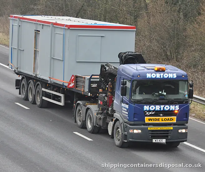 Grey portable cabin on a HIAB lorry marked wide load Grey portable cabin on a HIAB lorry marked wide load