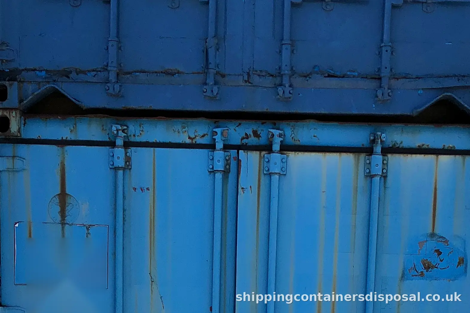 Wider view of stacked blue shipping containers beside one of our lorries Wider view of stacked blue shipping containers beside one of our lorries